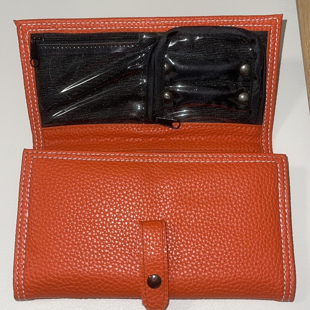 NEW- Leather, travel jewelry holder. Orange w/Slv.  met closure. 9 compartments.